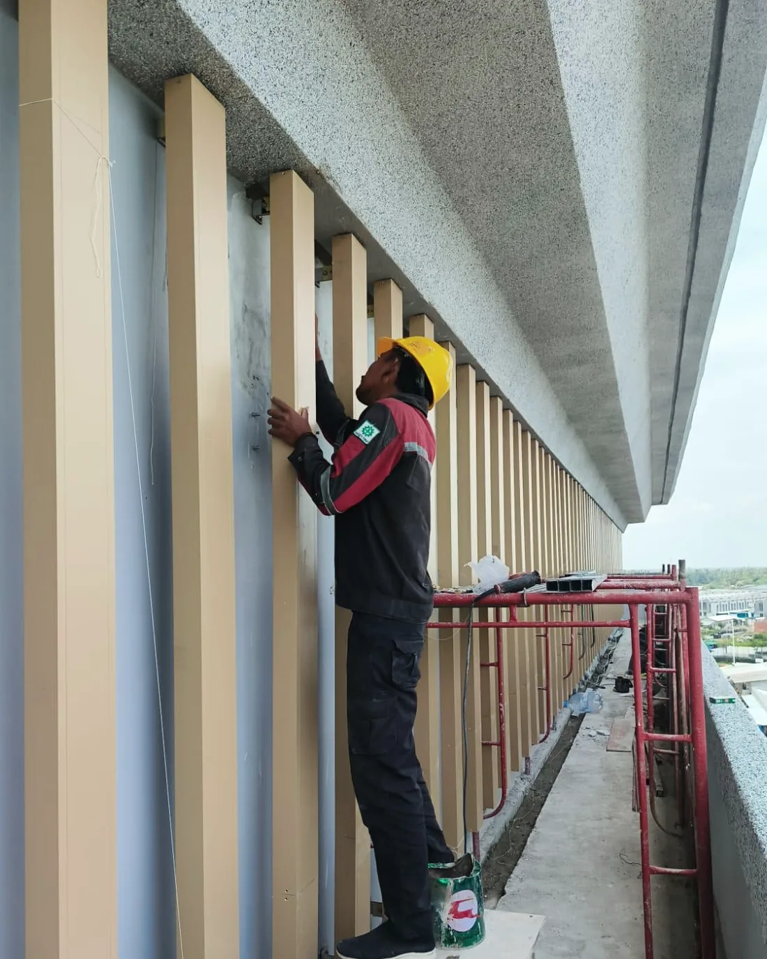 Teknisi memasang fin vertikal aluminium di muka gedung Buddha Tzu Chi PIK 2.